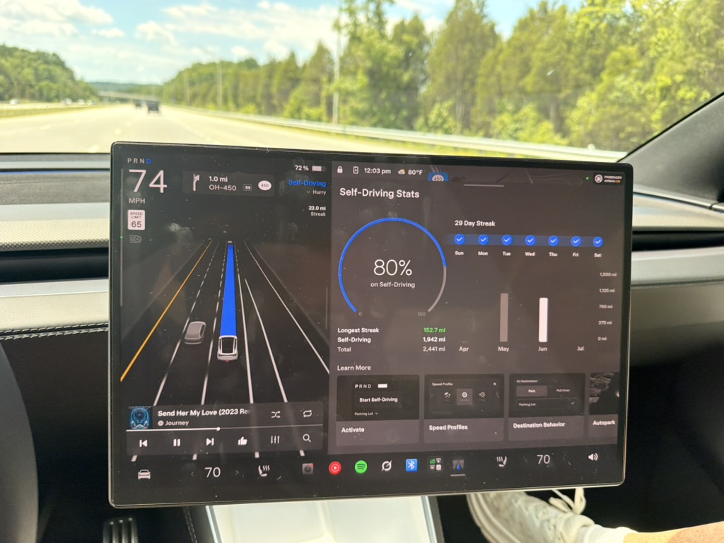 Tesla center screen displaying self-driving stats and miles driven on an Ohio highway