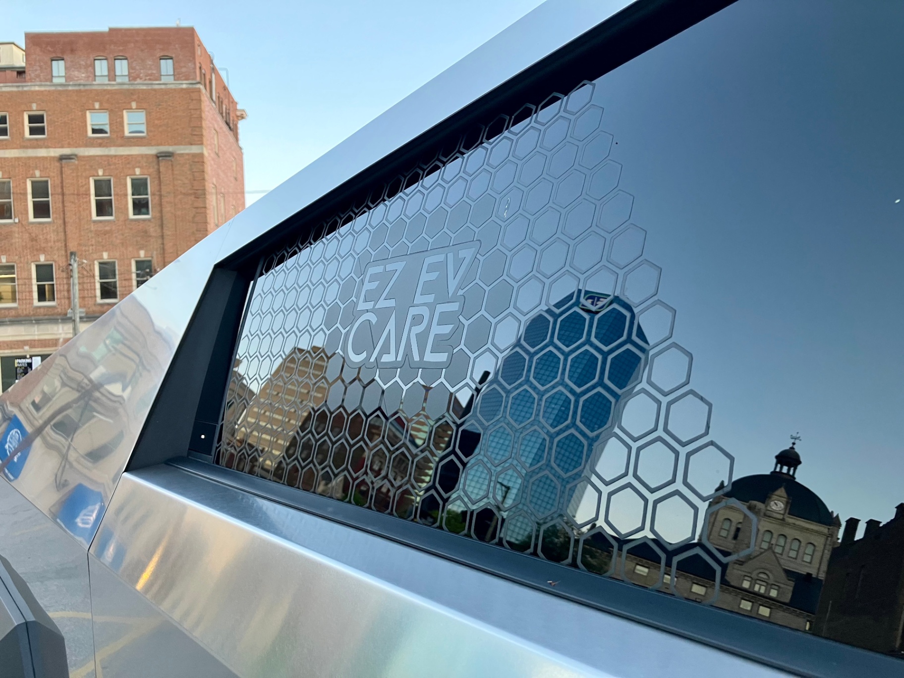 Tesla Cybertruck rear window with hexagonal EZ EV Care logo overlay