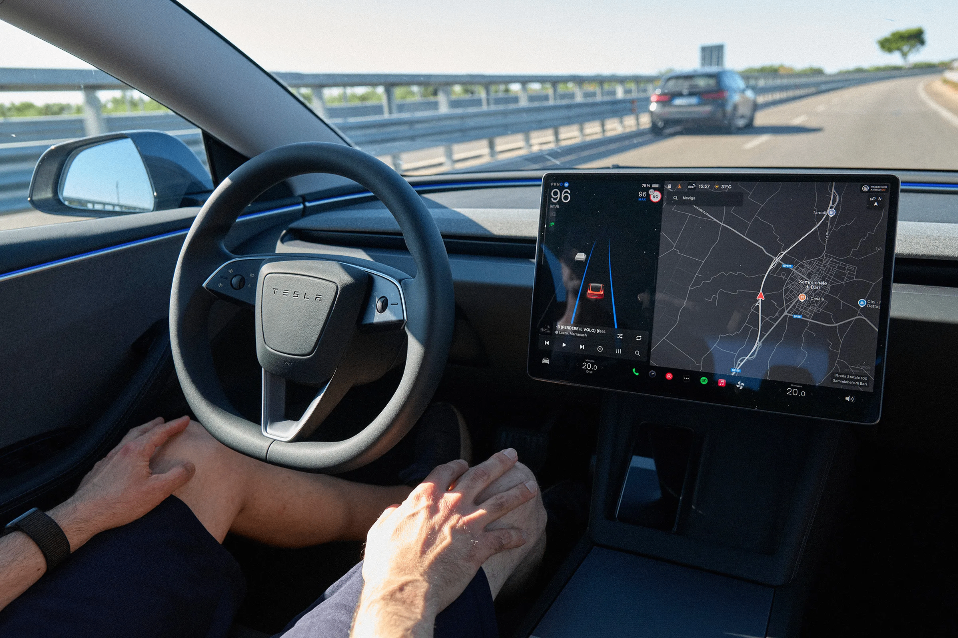 Interior view of a Tesla driving on a highway with the FSD visualization and navigation map on the center touchscreen