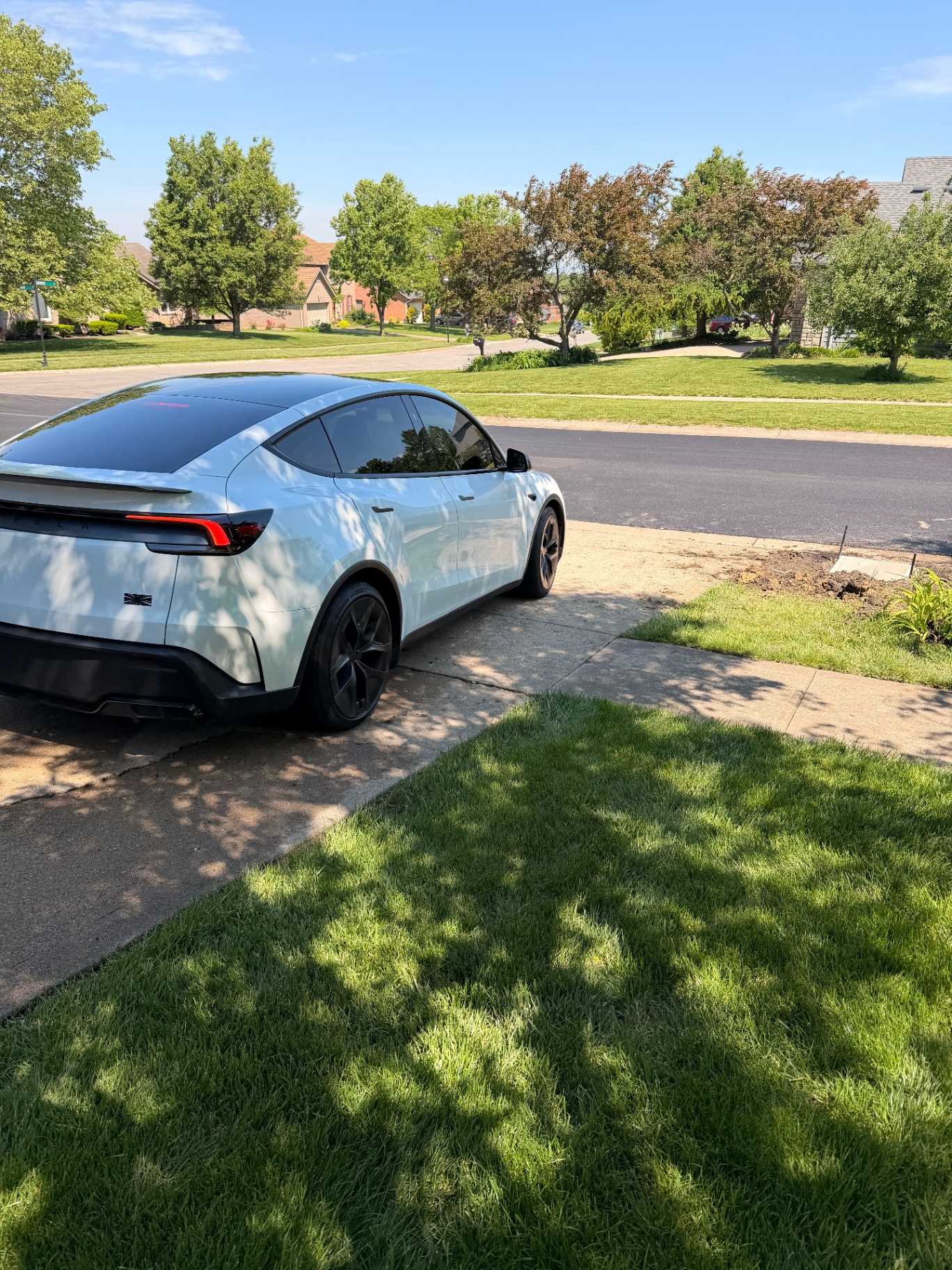 White Tesla Model Y Performance backed into an Ohio driveway on a sunny day