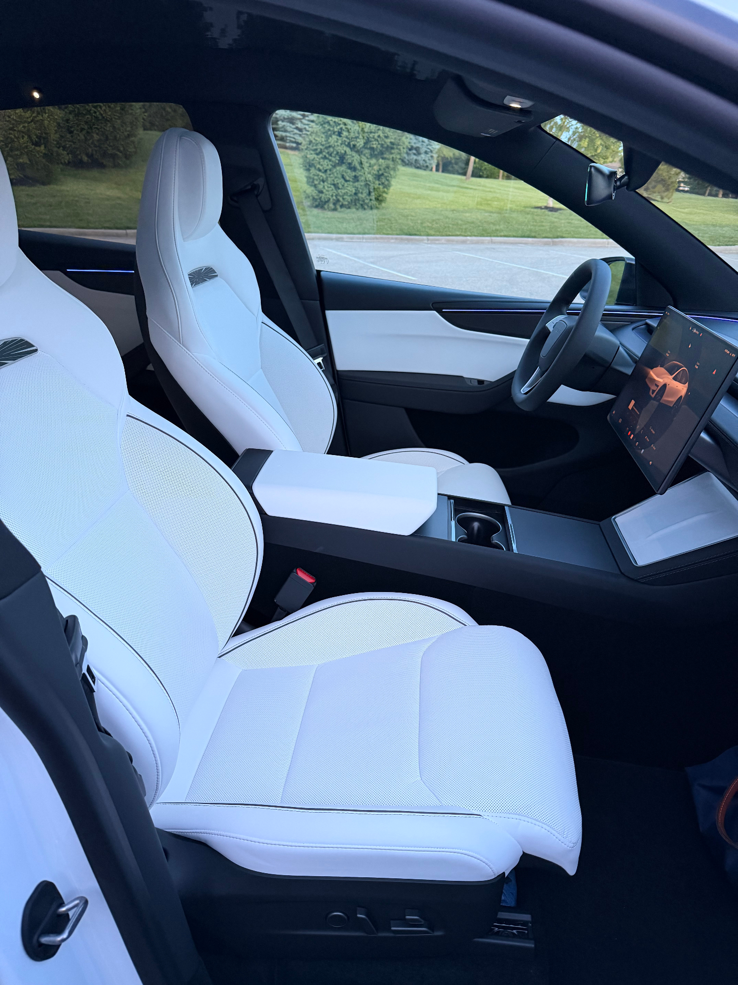 White Tesla Model Y Performance interior with white seats, panoramic roof, and center display