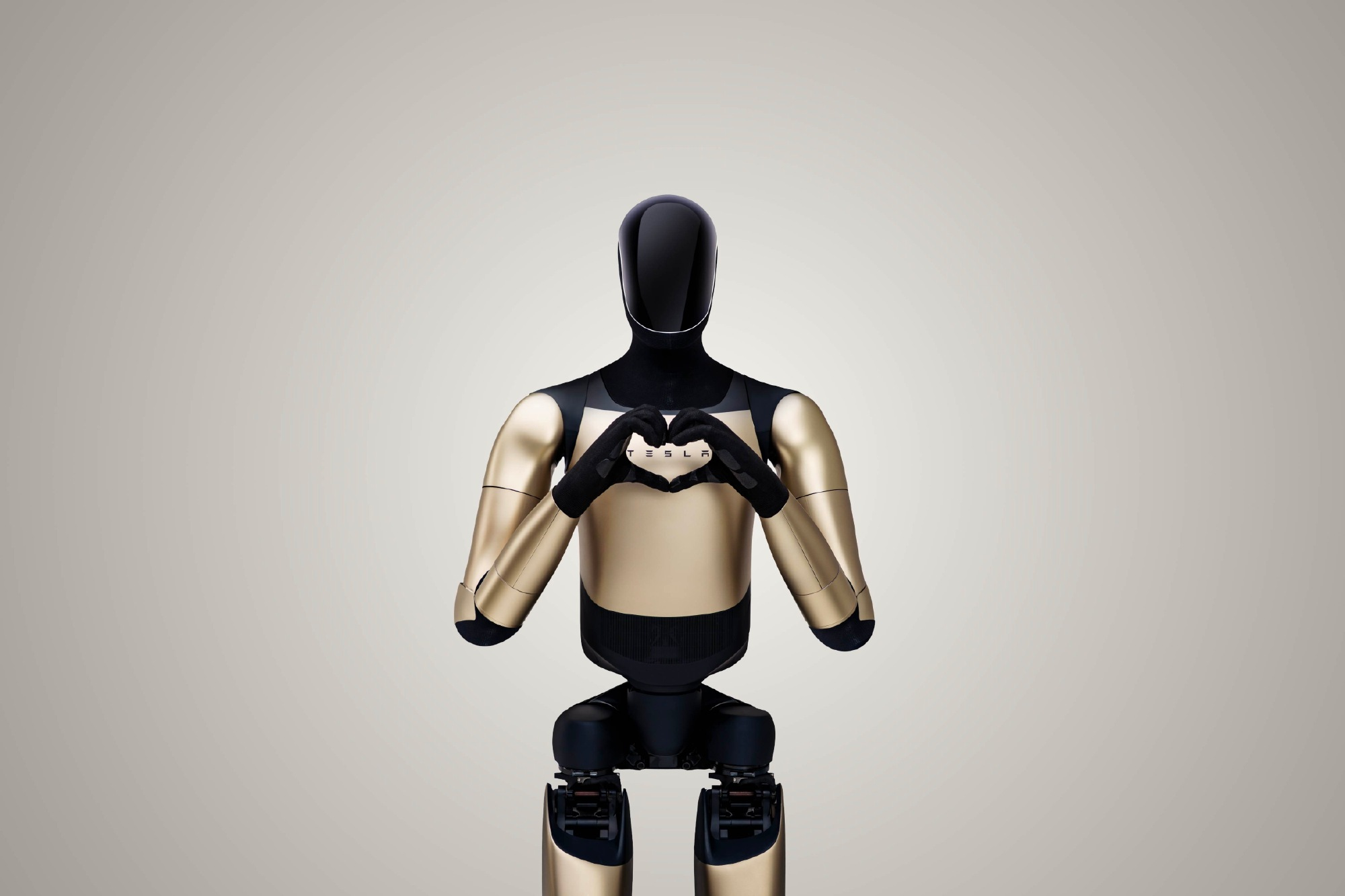 Tesla Optimus humanoid robot making a heart shape with its hands against a neutral studio background